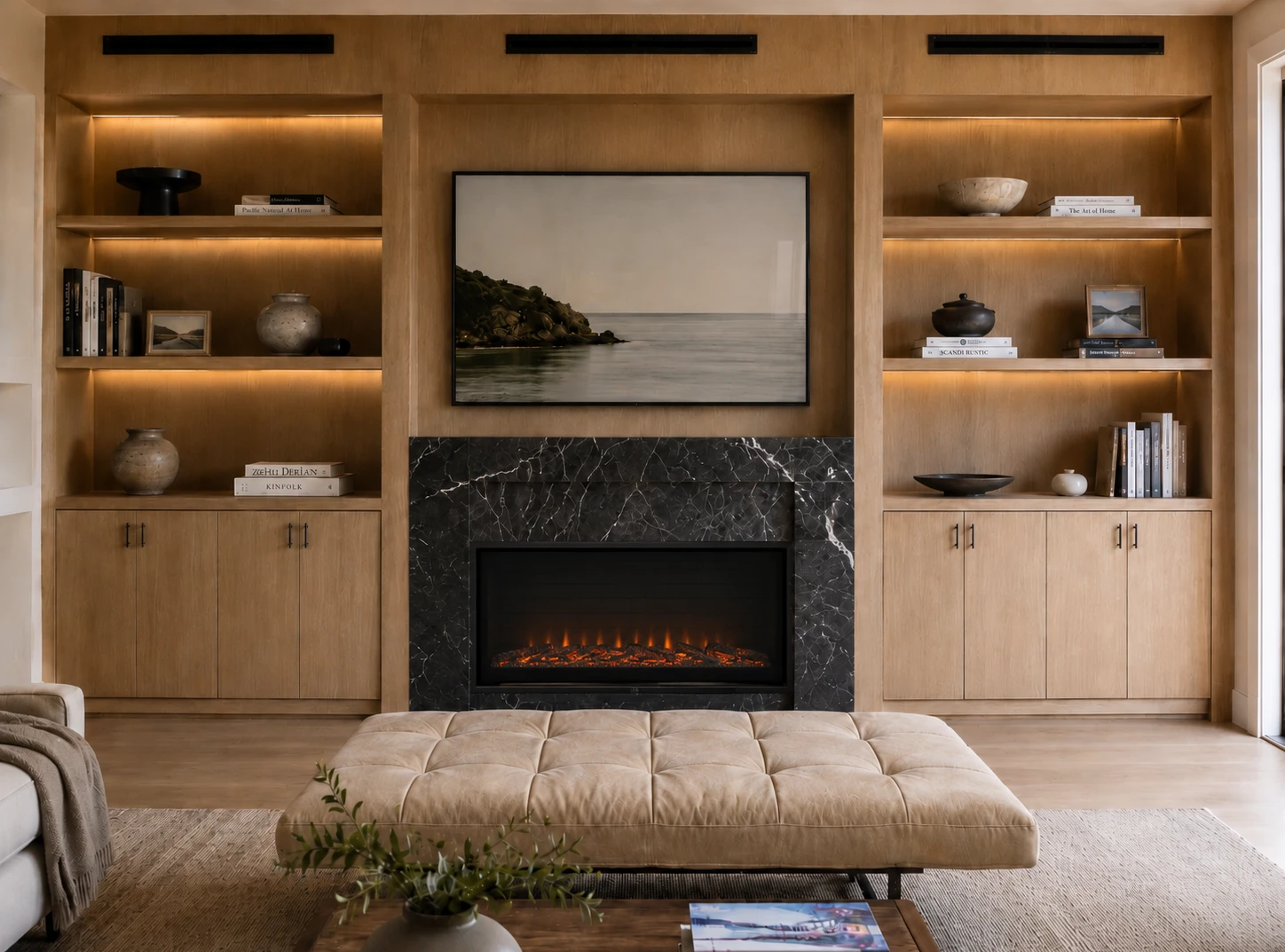 Full-wall oak built-in with integrated fireplace, black marble surround and LED shelf lighting
